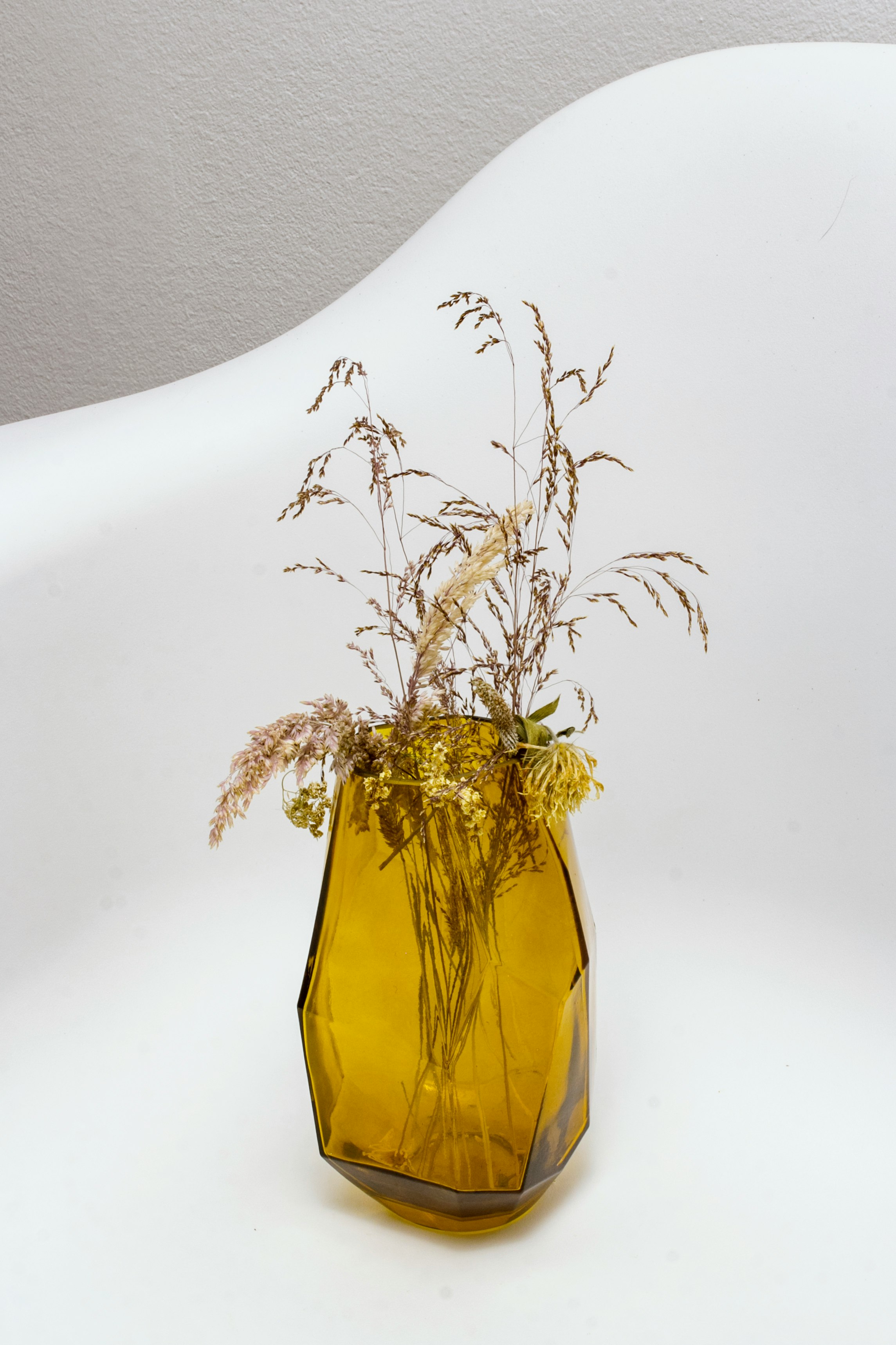 grasses in yellow translucent glass vase